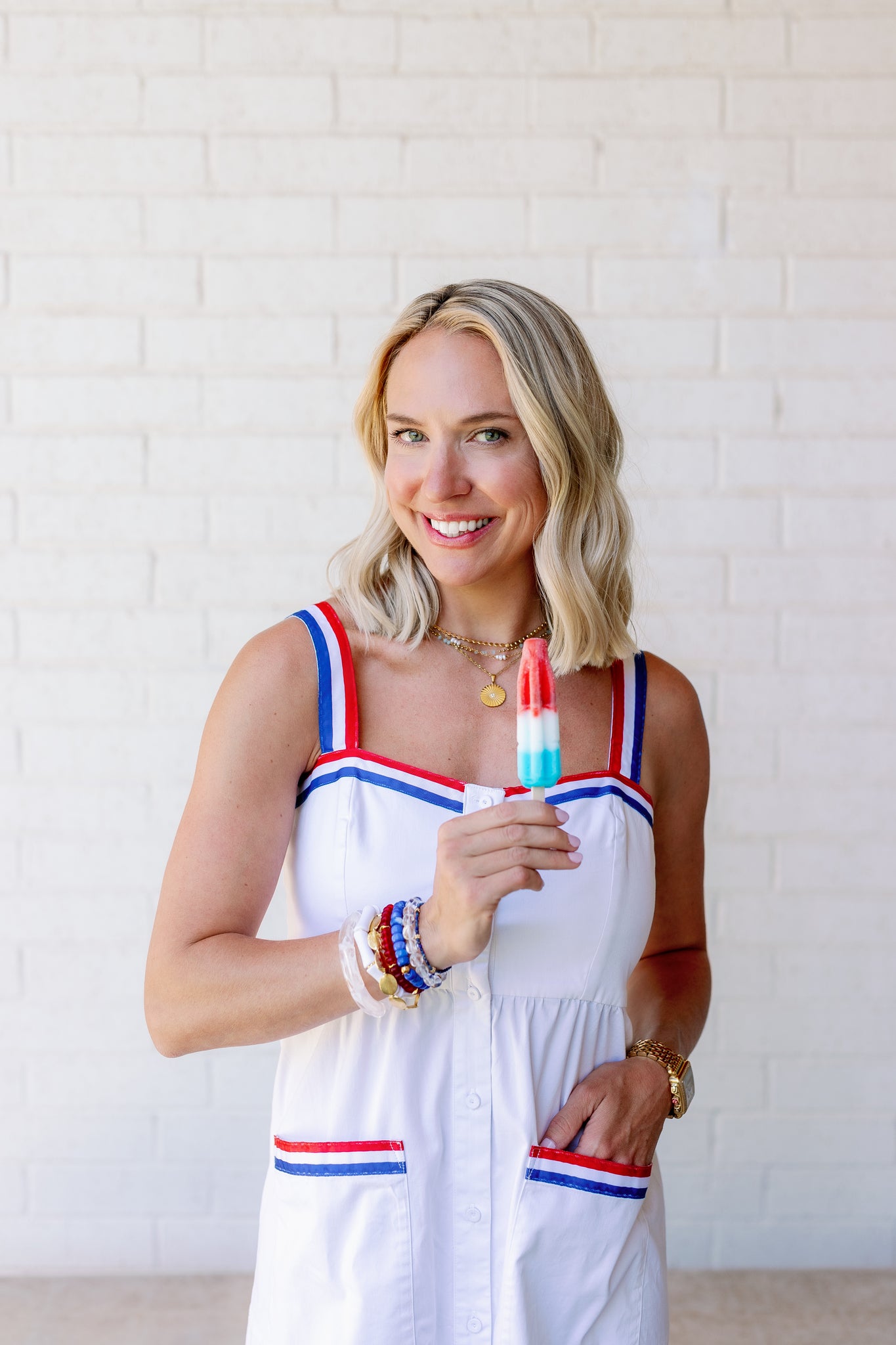 becca wearing 18K Gold Sunrise Pendant Necklace and a colorful stack of bracelets